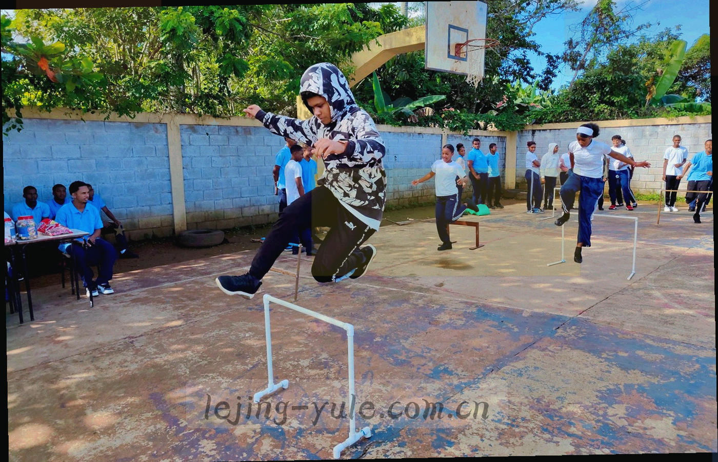 暗光工作台上排列的显示器与键盘，屏幕显示抽象赛程表格线条，无品牌标识